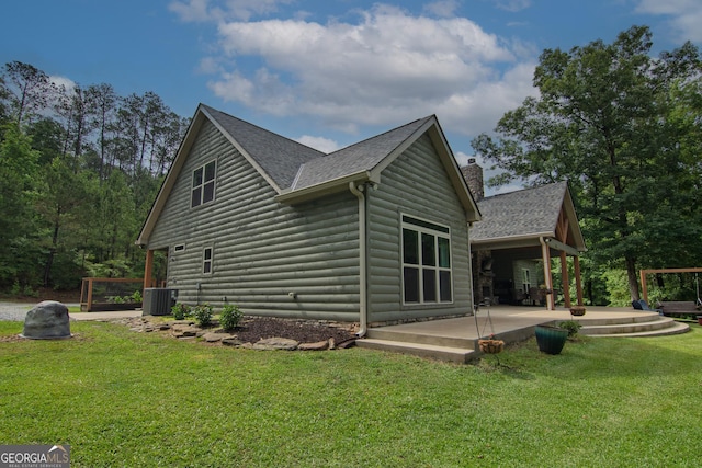 299 Savior Ln, Hamilton, GA 31811 - view of home's exterior with a patio area, central AC unit, a yard, a shingled roof, and faux log siding