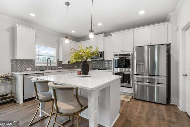 537 Garnet Dr, Acworth, GA 30101 - kitchen with appliances with stainless steel finishes, white cabinetry, a center island, light countertops, and ornamental molding