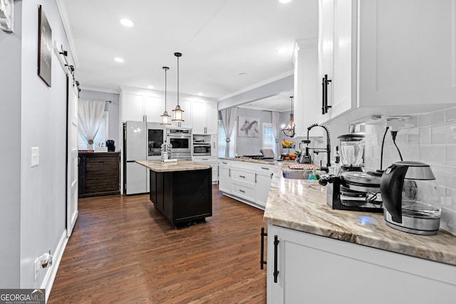 151 Dumar Ln, Hoschton, GA 30548 - kitchen with a sink, appliances with stainless steel finishes, crown molding, white cabinetry, and decorative backsplash