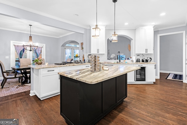 151 Dumar Ln, Hoschton, GA 30548 - kitchen featuring arched walkways, wine cooler, dark wood finished floors, a center island, and a chandelier
