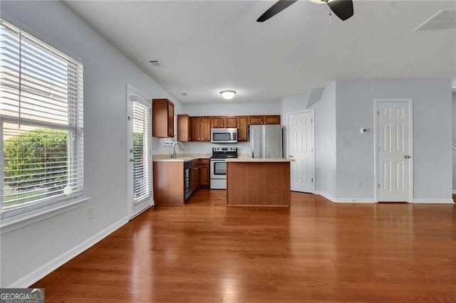 328 Oaktown Ct, Lawrenceville, GA 30044 - kitchen with stainless steel appliances, ceiling fan, light countertops, baseboards, and dark wood finished floors