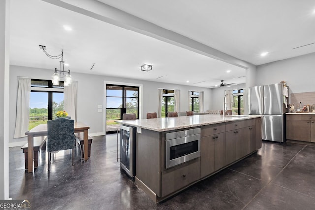 1971 Centennial Rd, Rutledge, GA 30663 - kitchen featuring freestanding refrigerator, wine cooler, a sink, a kitchen island, and plenty of natural light