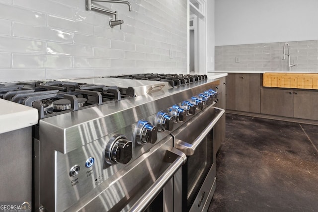 1971 Centennial Rd, Rutledge, GA 30663 - kitchen view of range with two ovens, backsplash, a sink, finished concrete flooring, and light countertops