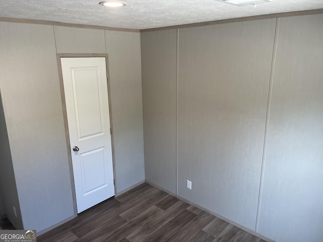 585 Elmer Thrift Rd, Waycross, GA 31503 - spare room with dark wood-style flooring, a decorative wall, and a textured ceiling