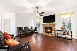 121 Royal Sunset Dr, Dallas, GA 30157 - living room featuring a lit fireplace, a ceiling fan, and wood finished floors