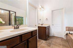 121 Royal Sunset Dr, Dallas, GA 30157 - full bathroom featuring two vanities, a bath, and a shower with shower door