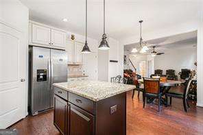121 Royal Sunset Dr, Dallas, GA 30157 - kitchen featuring stainless steel refrigerator with ice dispenser, a center island, hanging light fixtures, light stone countertops, and a ceiling fan