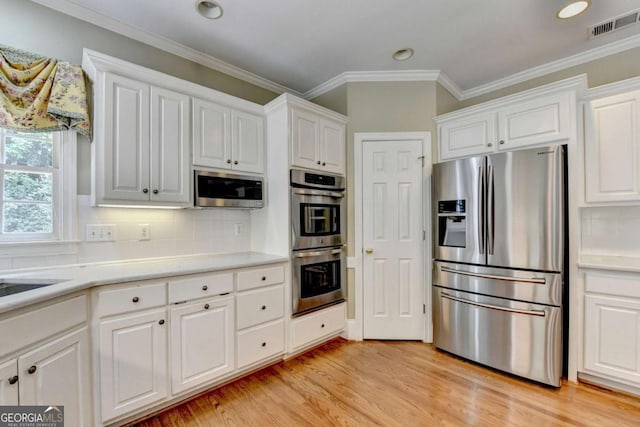 5980 Whitestone Ln, Suwanee, GA 30024 - kitchen featuring appliances with stainless steel finishes, light wood-style floors, white cabinetry, recessed lighting, and ornamental molding