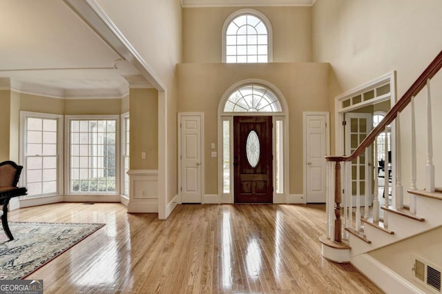 5980 Whitestone Ln, Suwanee, GA 30024 - entryway featuring wood finished floors, stairway, a towering ceiling, and crown molding