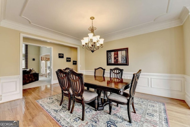 5980 Whitestone Ln, Suwanee, GA 30024 - dining room with a chandelier, light wood-type flooring, ornamental molding, and a wainscoted wall