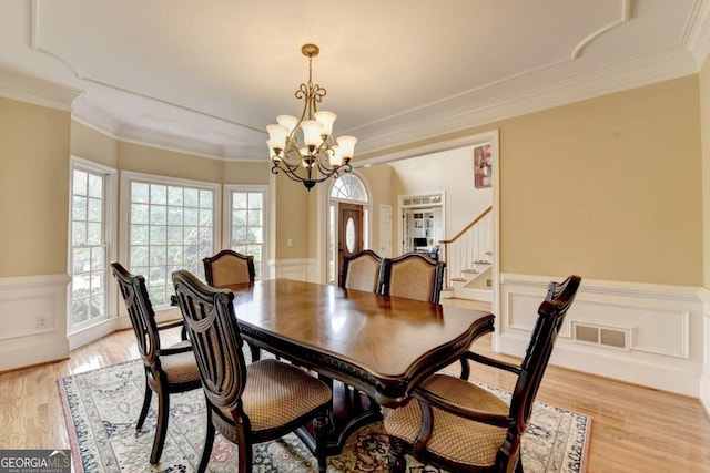 5980 Whitestone Ln, Suwanee, GA 30024 - dining room with a chandelier, wainscoting, light wood-style flooring, stairway, and crown molding