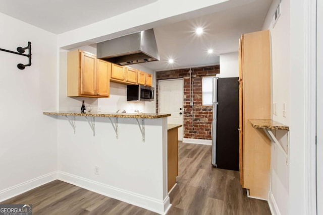 40 Daniel St SE, Atlanta, GA 30312 - kitchen featuring appliances with stainless steel finishes, a peninsula, baseboards, wall chimney range hood, and brick wall