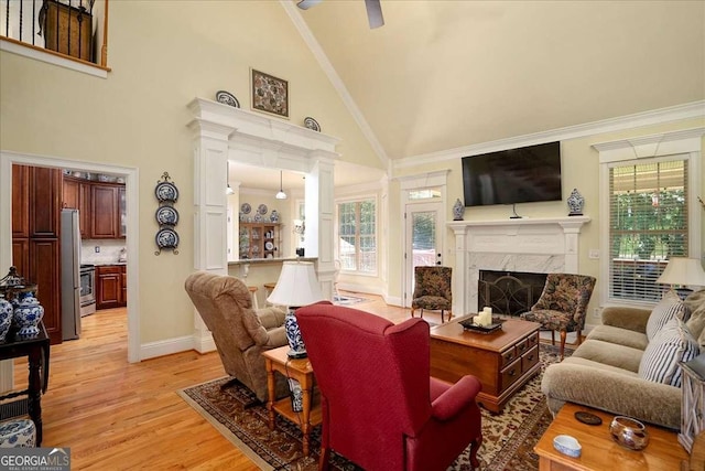 1917 Hearthstone Ct, Winder, GA 30680 - living room featuring high vaulted ceiling, decorative columns, light wood-style flooring, baseboards, and a high end fireplace