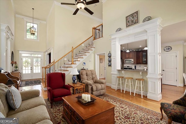 1917 Hearthstone Ct, Winder, GA 30680 - living area with ceiling fan, a high ceiling, stairway, light wood finished floors, and french doors
