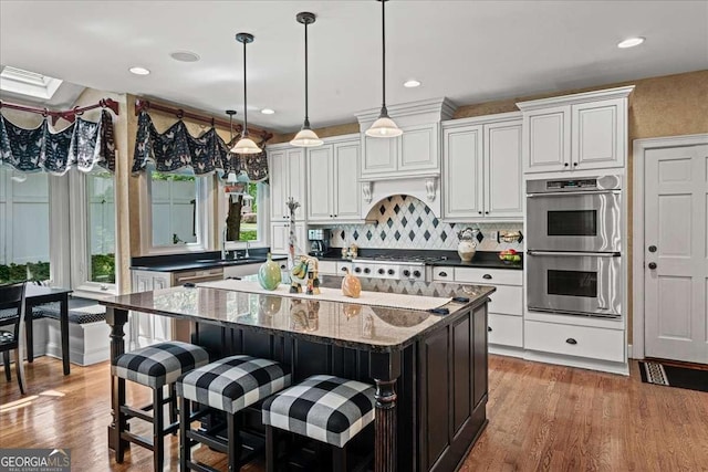 162 Daltree Ct, Marietta, GA 30068 - kitchen featuring double oven, a center island, gas cooktop, wood finished floors, and recessed lighting