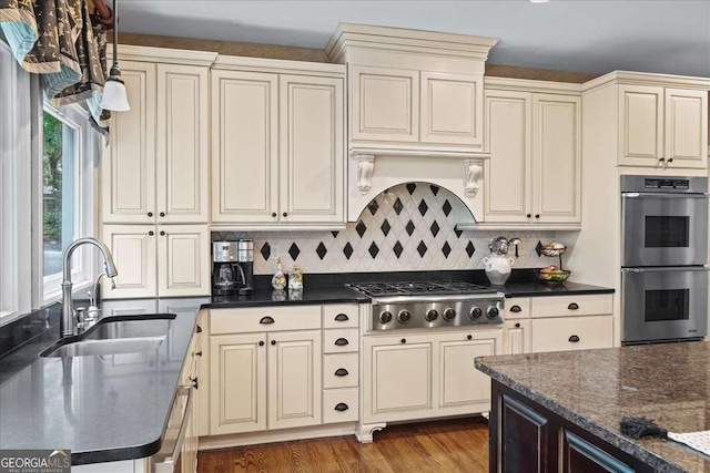 162 Daltree Ct, Marietta, GA 30068 - kitchen featuring appliances with stainless steel finishes, cream cabinets, decorative backsplash, and wood finished floors