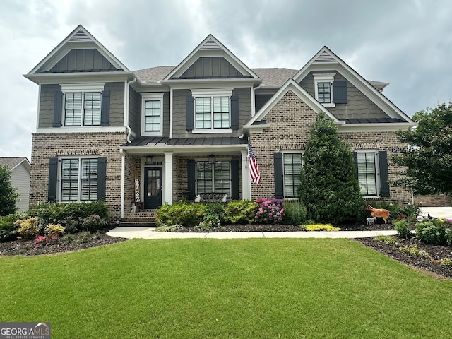 6722 Trail Side Dr, Flowery Branch, GA 30542 - craftsman-style home with brick siding, a front yard, a porch, a standing seam roof, and a shingled roof