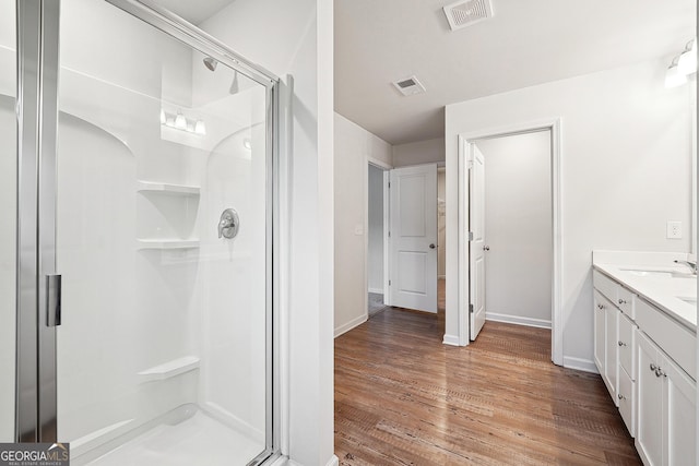 5207 Canberra Dr, Flowery Branch, GA 30542 - bathroom with a stall shower, vanity, and wood finished floors