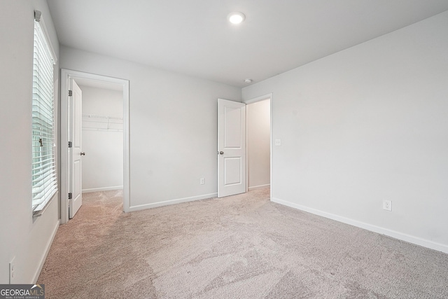 5207 Canberra Dr, Flowery Branch, GA 30542 - unfurnished bedroom with carpet flooring, a walk in closet, a closet, and recessed lighting