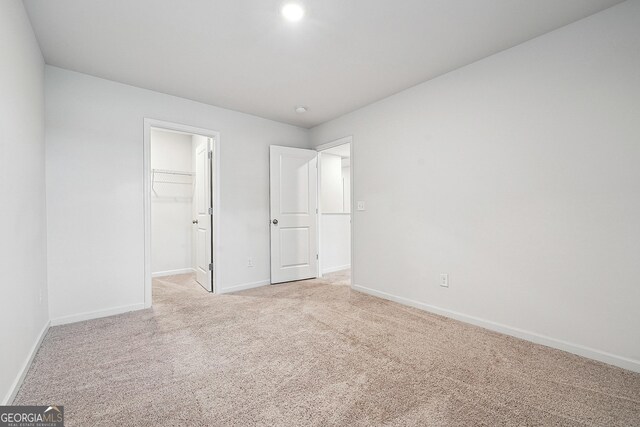 5207 Canberra Dr, Flowery Branch, GA 30542 - unfurnished bedroom with light carpet, a spacious closet, and a closet