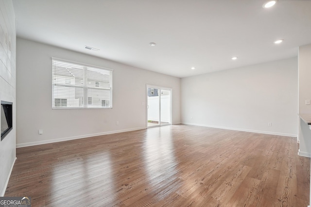5207 Canberra Dr, Flowery Branch, GA 30542 - unfurnished living room with a large fireplace, light wood-style floors, and recessed lighting