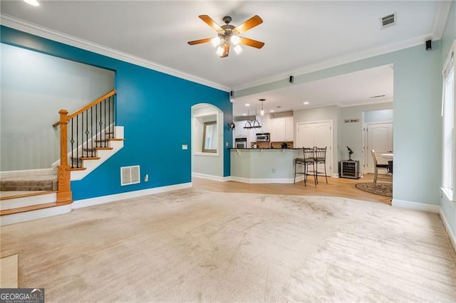 1210 Magnolia Park Cir, Cumming, GA 30040 - unfurnished living room featuring ceiling fan, ornamental molding, stairs, baseboards, and arched walkways
