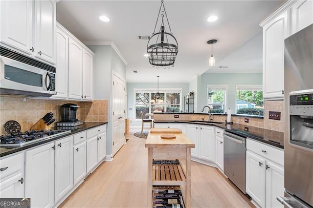 1210 Magnolia Park Cir, Cumming, GA 30040 - kitchen with stainless steel appliances, ornamental molding, plenty of natural light, recessed lighting, and light wood finished floors