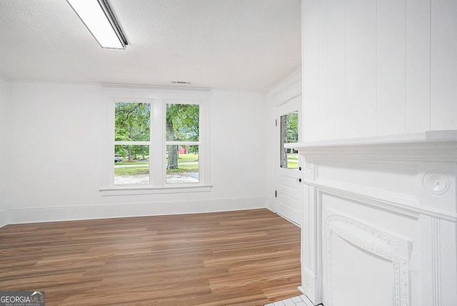 1852 Burwell Rd, Carrollton, GA 30117 - unfurnished living room with light wood finished floors, baseboards, and a textured ceiling