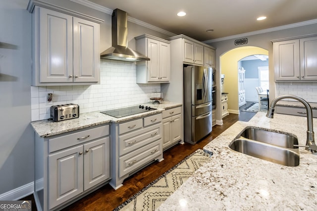 101 High Bluff Trl, Carrollton, GA 30116 - kitchen featuring stainless steel fridge, wall chimney range hood, a sink, arched walkways, and black electric cooktop