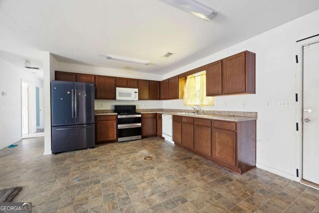 6770 Gordon Manor Ct SW, Mableton, GA 30126 - kitchen with white appliances, stone finish floors, and light countertops