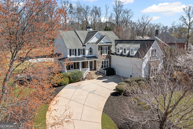 410 S Burgess Trl, Milton, GA 30004 - view of front facade featuring covered porch, a chimney, driveway, a garage, and stone siding