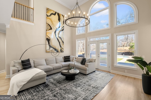 410 S Burgess Trl, Milton, GA 30004 - living area featuring light wood-style floors, crown molding, french doors, a chandelier, and baseboards