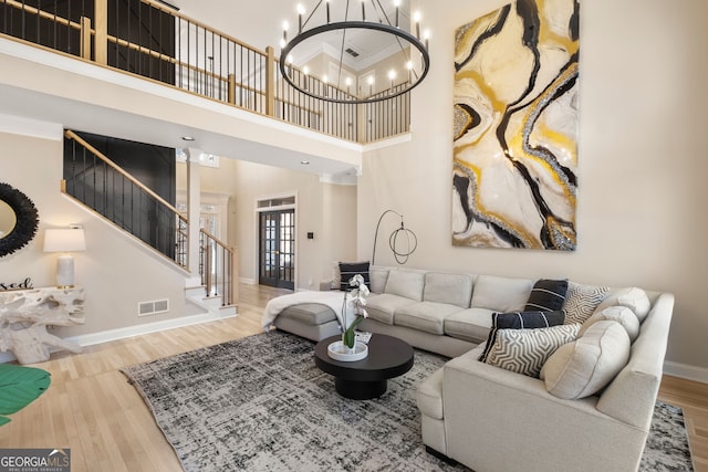 410 S Burgess Trl, Milton, GA 30004 - living room featuring a towering ceiling, stairs, baseboards, wood finished floors, and a chandelier