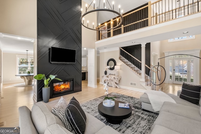 410 S Burgess Trl, Milton, GA 30004 - living room with a high ceiling, a chandelier, decorative columns, baseboards, and wood finished floors