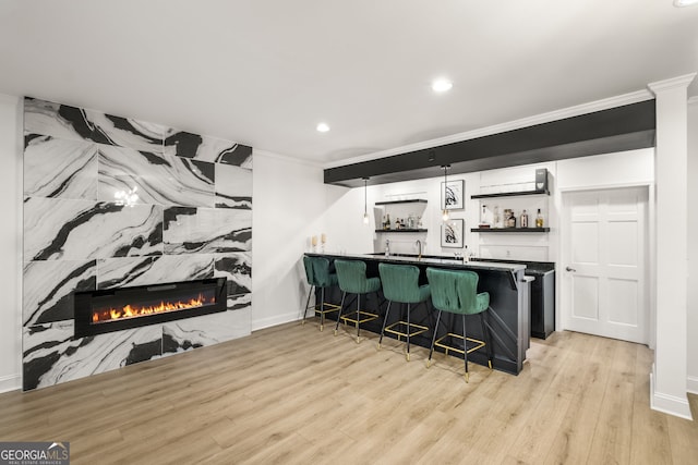 410 S Burgess Trl, Milton, GA 30004 - indoor wet bar featuring ornamental molding, light wood finished floors, recessed lighting, a large fireplace, and baseboards