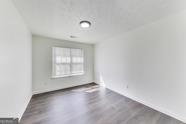 131 Turning Pt, Stockbridge, GA 30281 - unfurnished room featuring dark wood-style flooring and a textured ceiling