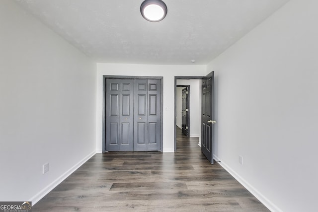 131 Turning Pt, Stockbridge, GA 30281 - unfurnished bedroom with baseboards, wood finished floors, and a closet