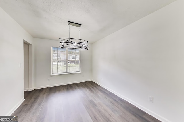 131 Turning Pt, Stockbridge, GA 30281 - unfurnished room featuring a chandelier, dark wood-style floors, and baseboards