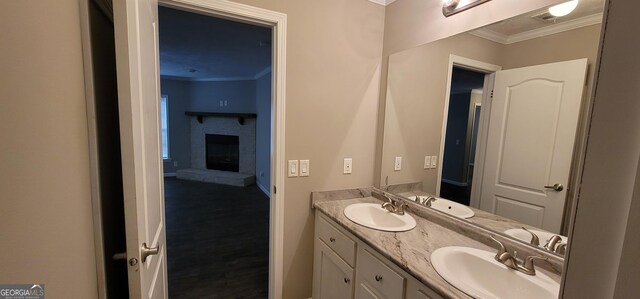 4373 Whiporwill Rd, Gillsville, GA 30543 - bathroom with crown molding, double vanity, baseboards, a brick fireplace, and wood finished floors