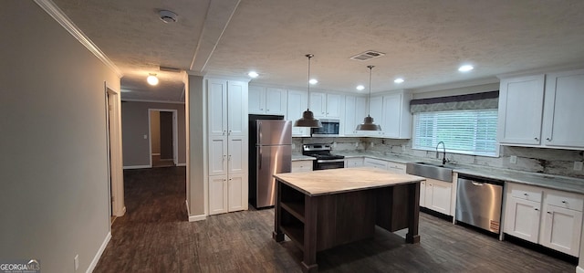 4373 Whiporwill Rd, Gillsville, GA 30543 - kitchen featuring appliances with stainless steel finishes, a sink, crown molding, tasteful backsplash, and white cabinets