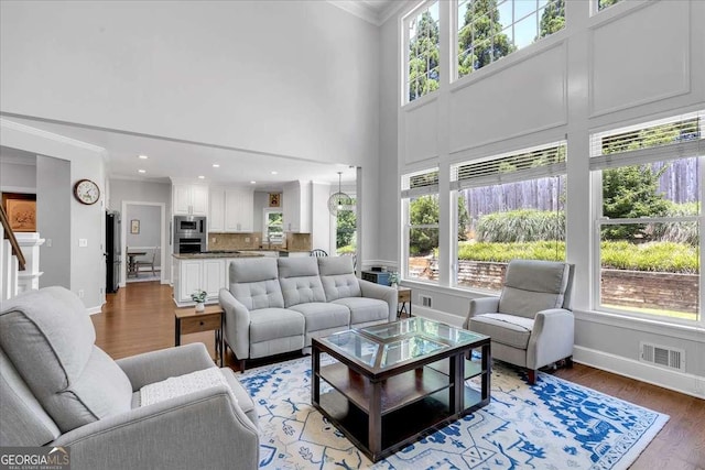 3400 Dencrest Ct SE, Smyrna, GA 30080 - living room with ornamental molding, light wood finished floors, baseboards, recessed lighting, and a towering ceiling