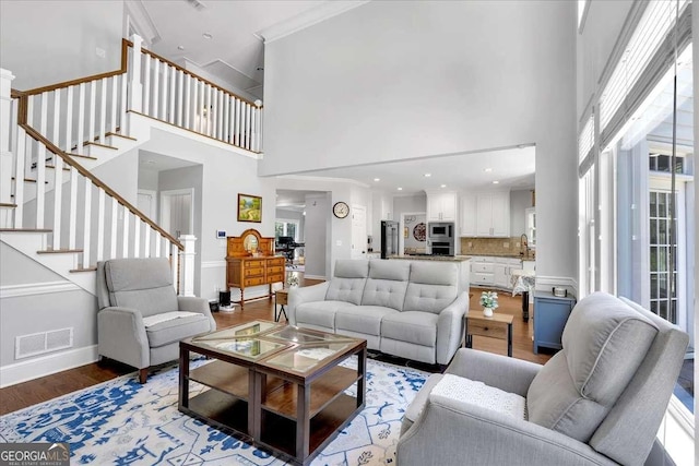 3400 Dencrest Ct SE, Smyrna, GA 30080 - living room featuring light wood-style flooring, a high ceiling, stairway, and baseboards