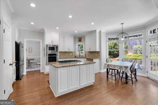 3400 Dencrest Ct SE, Smyrna, GA 30080 - kitchen with appliances with stainless steel finishes, a chandelier, white cabinetry, crown molding, and decorative backsplash