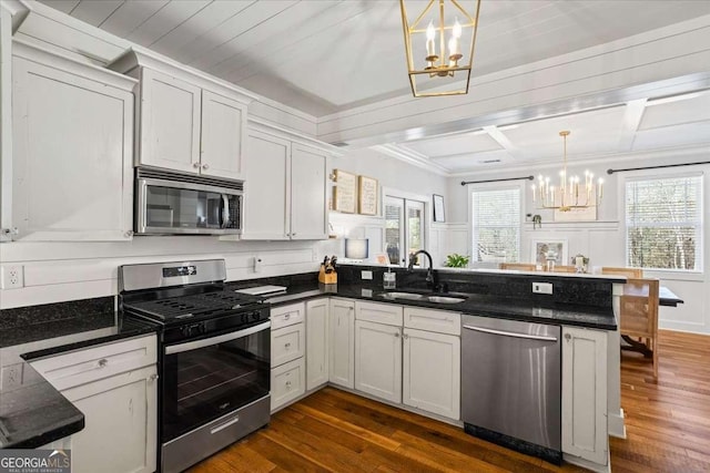 2291 Mission Oak Ter, Grayson, GA 30017 - kitchen with stainless steel appliances, a chandelier, a sink, a peninsula, and dark wood finished floors