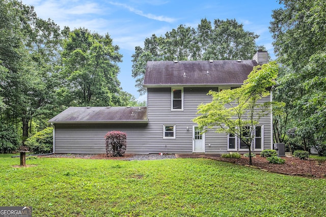 844 Potomac Pl, Winder, GA 30680 - back of property featuring a lawn, a shingled roof, a chimney, and central air condition unit