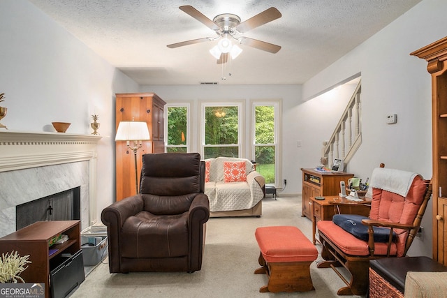 844 Potomac Pl, Winder, GA 30680 - living area featuring light colored carpet, a ceiling fan, a textured ceiling, a premium fireplace, and stairway