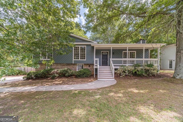 3404 Broxton Mill Way, Snellville, GA 30039 - split level home with covered porch, a front lawn, a chimney, stairs, and brick siding