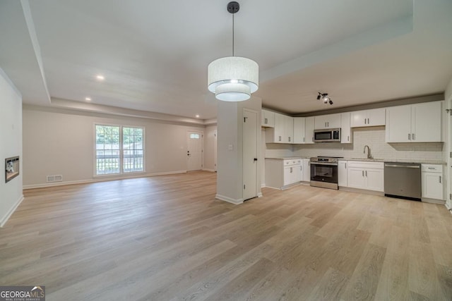 3404 Broxton Mill Way, Snellville, GA 30039 - kitchen featuring appliances with stainless steel finishes, open floor plan, light wood-type flooring, light countertops, and white cabinets