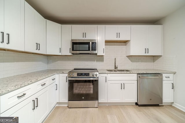 3404 Broxton Mill Way, Snellville, GA 30039 - kitchen with stainless steel appliances, light wood-style floors, white cabinets, and tasteful backsplash