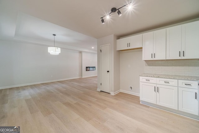 3404 Broxton Mill Way, Snellville, GA 30039 - kitchen with rail lighting, light wood-type flooring, decorative backsplash, white cabinets, and hanging light fixtures